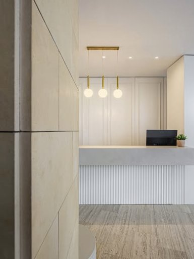 Minimal white reception desk with gold pendant lights
